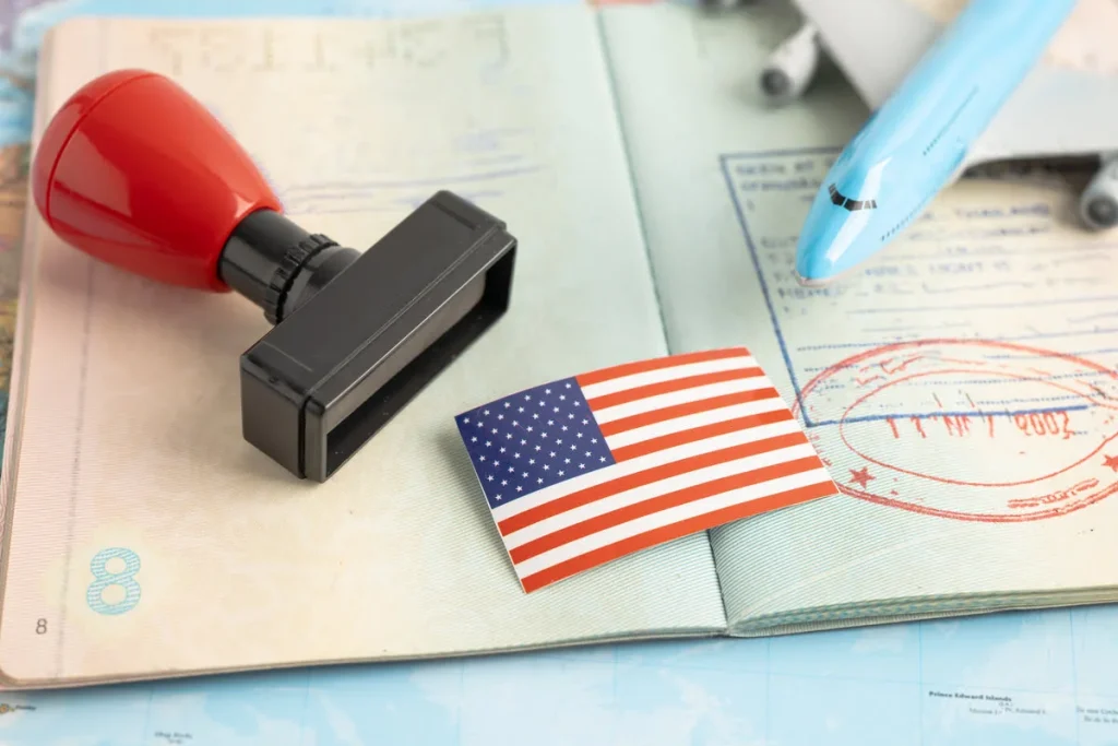open passport with an approval stamp, U.S. flag, and a toy airplane, symbolizing immigration success.