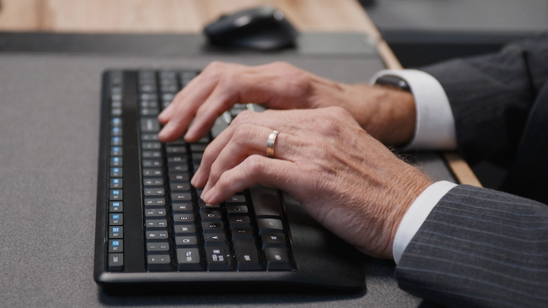 Consultor profesional mecanografiando en un teclado durante la evaluación de la visa para Estados Unidos